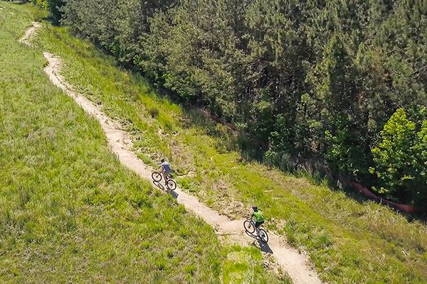 Overhead view of bikers riding along natural trail in Wendell Falls