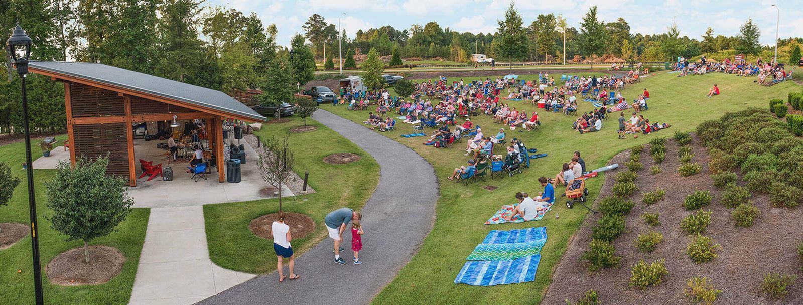Community gathering for outdoor concert event in Wendell Falls.