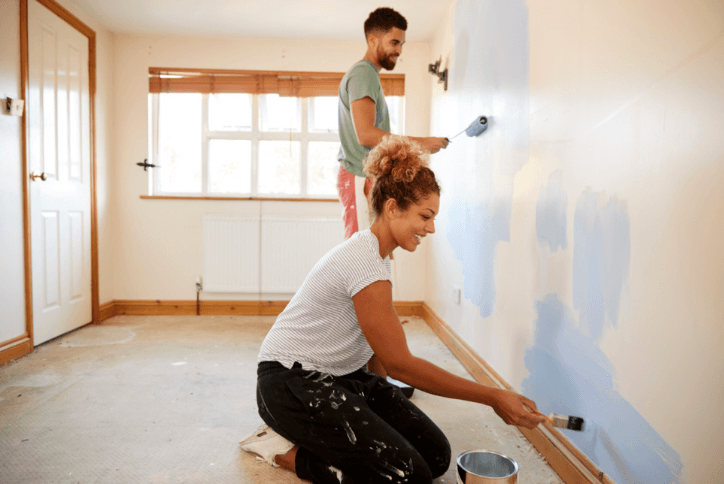 Couple painting walls in new home