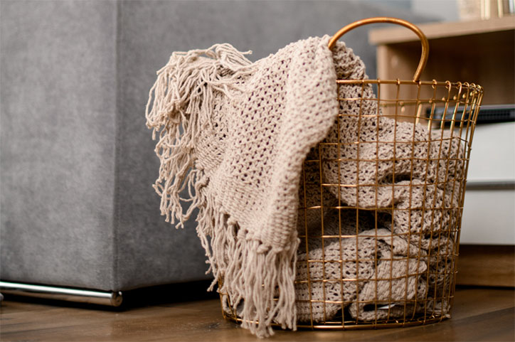 Wire basket holding blankets for storage