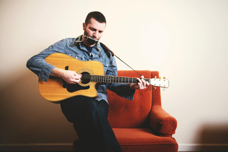 Kevin playing harmonica and acoustic guitar