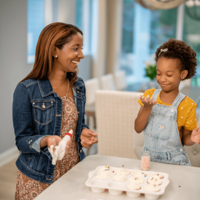 Mom and daughter enjoying baking cupcakes